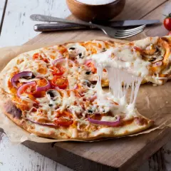 Rozciągający się ser z pizzy z pomidorami, cebulą i pieczarkami na desce.