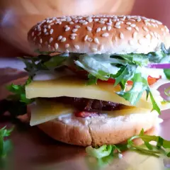 Pyszny jalapeno burger z dwoma plastrami sera, soczystą wołowiną, świeżą sałatą i sosem.