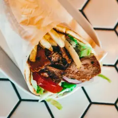 Pyszny kebab z mięsem, frytkami, warzywami i sosem. Idealny na szybki posiłek, choć warto pamiętać o jego kcal.