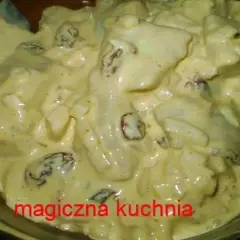 Kremowy sos golden mayo z kawałkami kurczaka i rodzynkami, serwowany w szklanej misce.