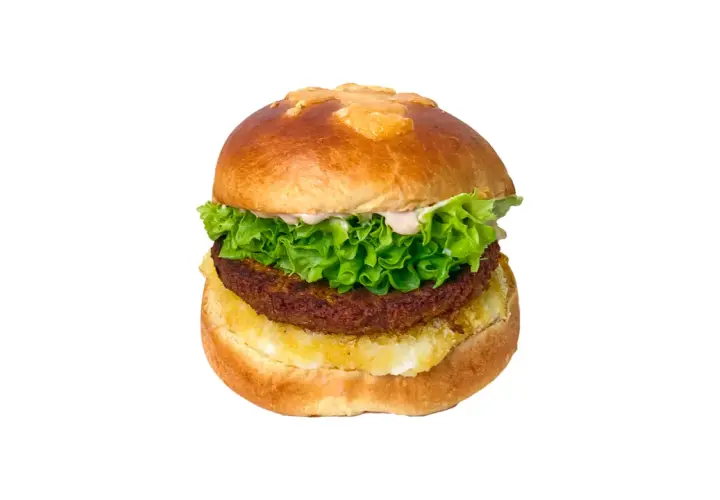 Apetyczny vege drwal z chrupiącą sałatą, kremowym sosem i soczystym kotletem na puszystej bułce.