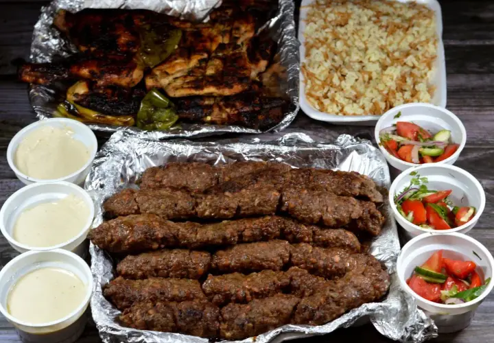 Pyszny kofta kebab z ryżem, sałatkami i sosami.