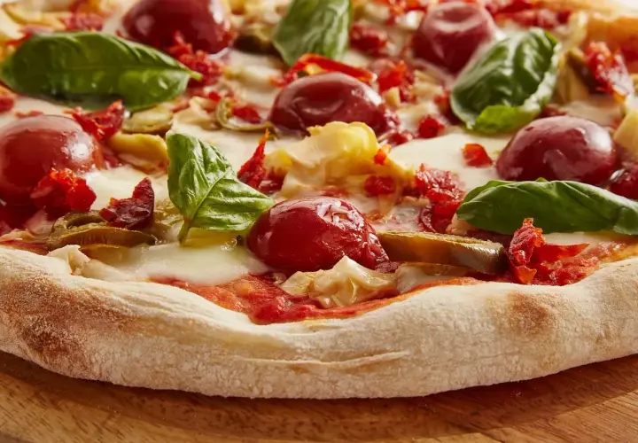 Pyszna pizza z pomidorkami, mozzarellą i bazylią. Trudno policzyć, ile kawałków ma ta pizza, ale wygląda apetycznie!