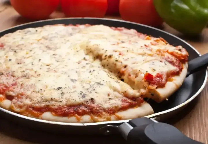 Gorąca, mrożona pizza z ciągnącym się serem, podana prosto z patelni. Idealna na szybki obiad.