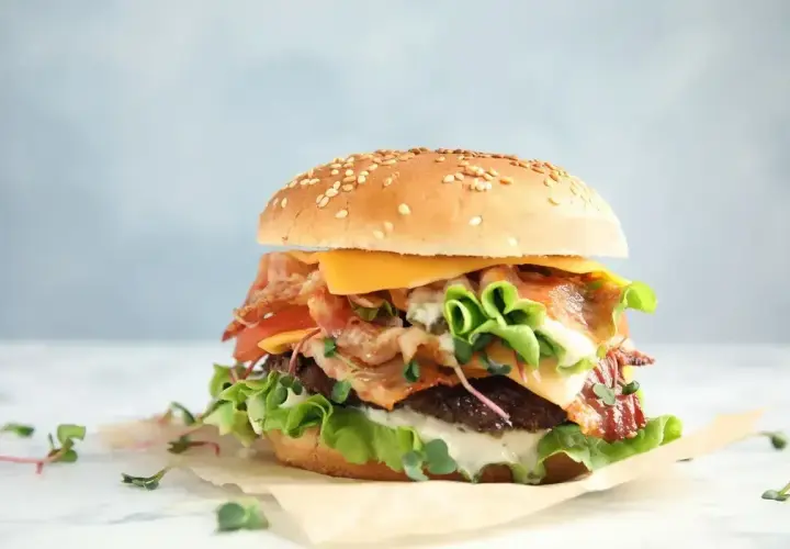 Pyszny burger z bekonem, serem i świeżymi warzywami. Czy to ten słynny red chikker z McDonald's? Ciekawe, ile ma kcal!