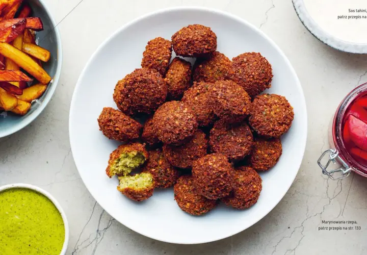 Talerz pełen chrupiących kulek falafel. Co to jest falafel? To smażone kulki z ciecierzycy, idealne do sosu tahini.