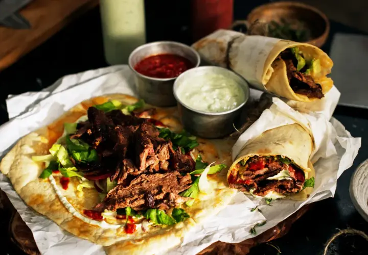 Pyszny lawasz kebab z soczystym mięsem, świeżą sałatą i sosami. Idealny na szybki posiłek.