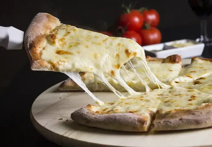 Rozciągający się ser na kawałku pizzy. Czy można mrozic ciasto na pizze? Tak, to świetny sposób na zachowanie świeżości.