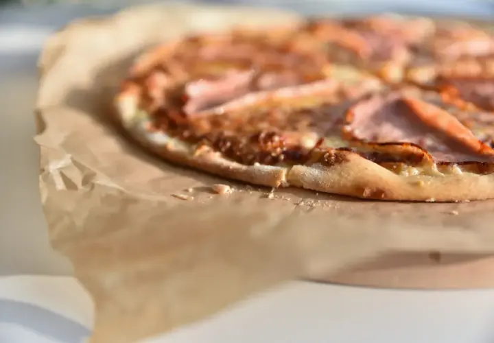 Apetyczna pizza na papierze do pieczenia. Wartości odżywcze pizzy z Pizza Hut mogą się różnić w zależności od składników.