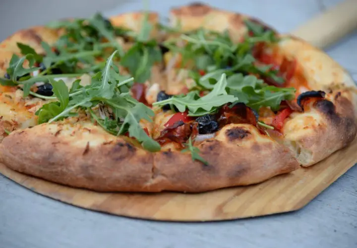 Pyszna pizza domowa na blachę, z przepisem na świeże drożdże, z rukolą i oliwkami.