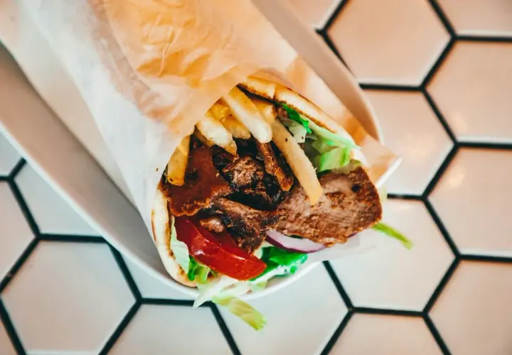 Pyszny kebab z mięsem, frytkami, warzywami i sosem. Idealny na szybki posiłek, choć warto pamiętać o jego kcal.