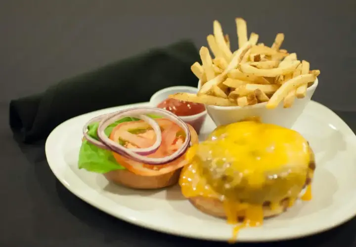 Pyszny burger z serem, frytki i ketchup. Czym się różni hamburger od burgera? Ten wygląda na pyszny!