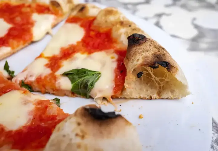 Kawałki pysznej pizza classica z ciągnącym się serem, sosem pomidorowym i bazylią. Idealna na szybki posiłek.