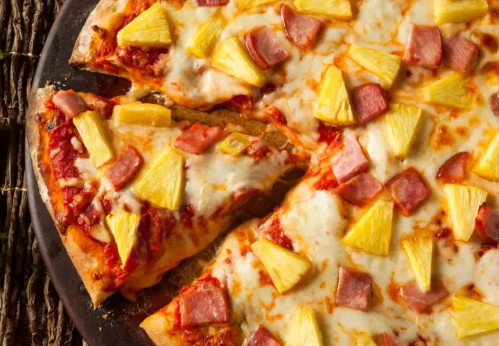 Pyszna pizza z ananasem i szynką, z ciągnącym się serem i chrupiącym ciastem. Idealna na szybki obiad.