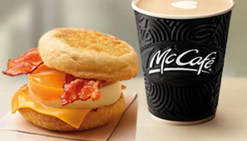 McMuffin z jajkiem, serem i bekonem obok kubka McCafe. Idealny zestaw na śniadanie.