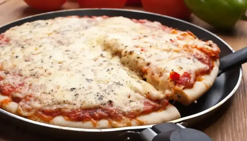Gorąca, mrożona pizza z ciągnącym się serem, podana prosto z patelni. Idealna na szybki obiad.