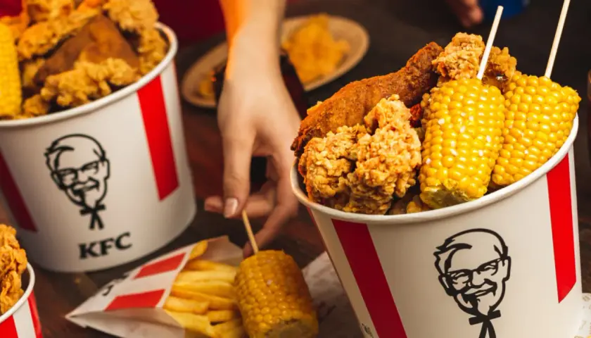 Kentucky Gold Grandeur: kubełki KFC z chrupiącym kurczakiem, kolbami kukurydzy i frytkami. Idealne na wspólne jedzenie, choć kalorie mogą przyprawić o zawrót głowy.