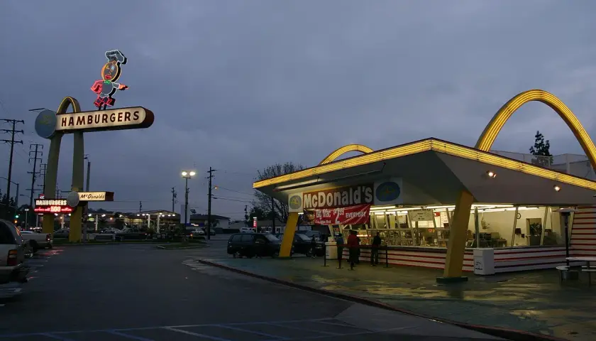 Stary McDonald's z neonem "Hamburgers" i łukami. To miejsce przypomina czasy, kiedy powstał McDonald's.