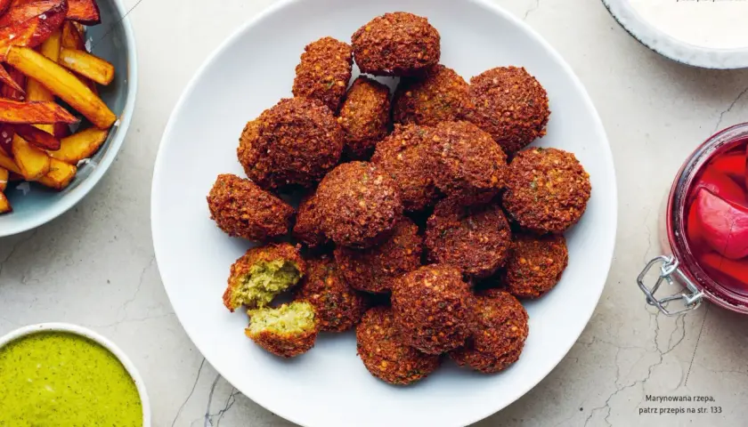 Talerz pełen chrupiących kulek falafel. Co to jest falafel? To smażone kulki z ciecierzycy, idealne do sosu tahini.