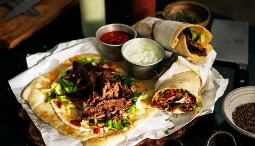 Pyszny lawasz kebab z soczystym mięsem, świeżą sałatą i sosami. Idealny na szybki posiłek.