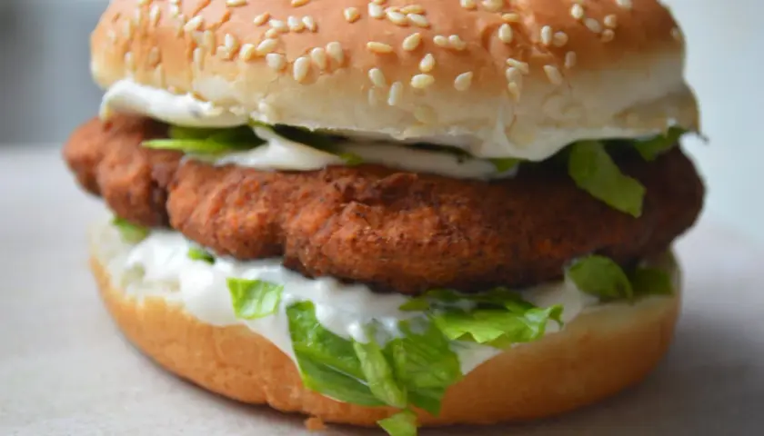 Soczysty burger z panierowanym, **red chikker** w bułce z sezamem, sałatą i majonezem.