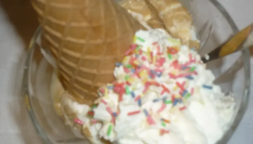 Lodowe marzenie w pucharku: lody waniliowe, wafel i kolorowa posypka. Idealne na gorący dzień.