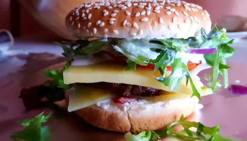 Pyszny jalapeno burger z dwoma plastrami sera, soczystą wołowiną, świeżą sałatą i sosem.