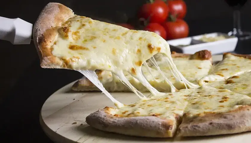 Rozciągający się ser na kawałku pizzy. Czy można mrozic ciasto na pizze? Tak, to świetny sposób na zachowanie świeżości.