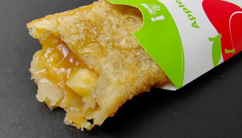 Chrupiące ciastko jabłkowe McDonald's z widocznym nadzieniem. Idealne na szybką przekąskę, choć warto sprawdzić jego kcal.