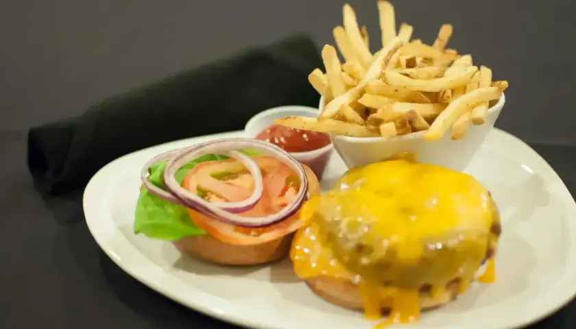 Pyszny burger z serem, frytki i ketchup. Czym się różni hamburger od burgera? Ten wygląda na pyszny!
