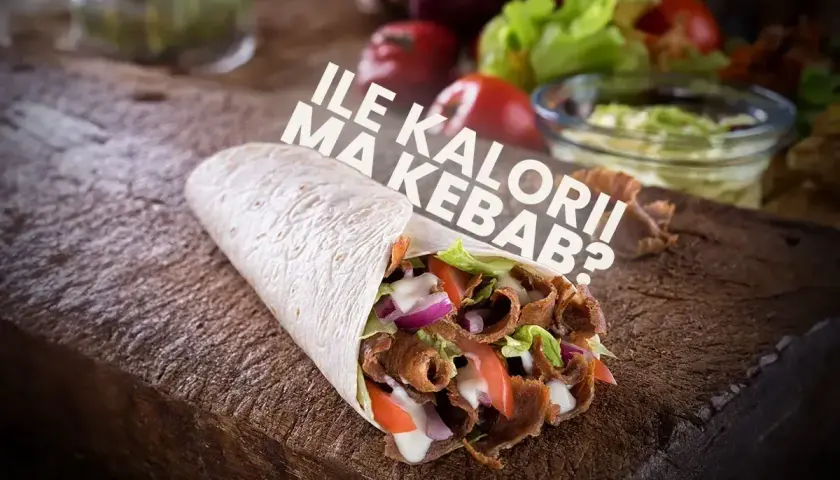 Pyszny kebab na drewnianej desce, z napisem "Ile kalorii ma kebab?".