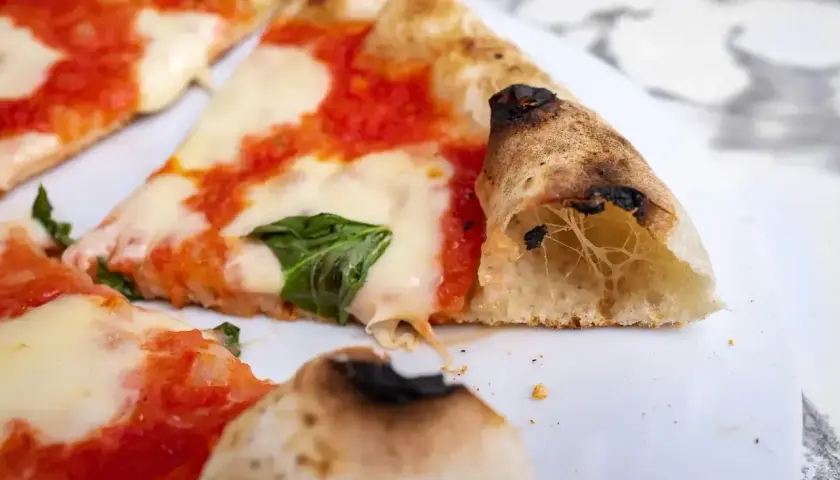 Kawałki pysznej pizza classica z ciągnącym się serem, sosem pomidorowym i bazylią. Idealna na szybki posiłek.