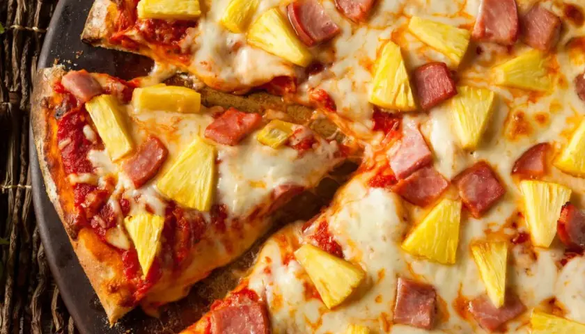 Pyszna pizza z ananasem i szynką, z ciągnącym się serem i chrupiącym ciastem. Idealna na szybki obiad.