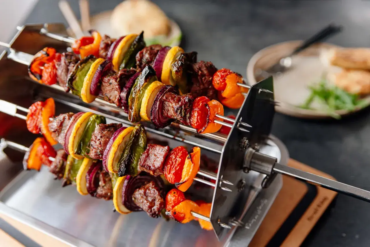 Pyszny shish kebab przepis: soczyste mięso, papryka, cebula i cukinia na rożnie, gotowe do grillowania.