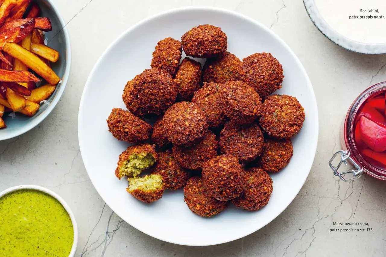 Talerz pełen chrupiących kulek falafel. Co to jest falafel? To smażone kulki z ciecierzycy, idealne do sosu tahini.