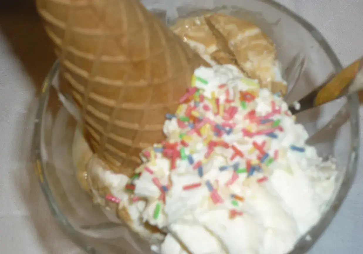 Lodowe marzenie w pucharku: lody waniliowe, wafel i kolorowa posypka. Idealne na gorący dzień.
