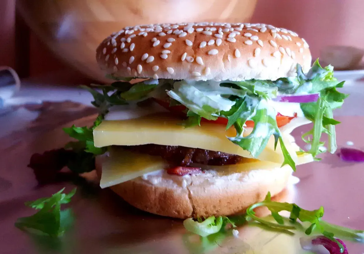 Pyszny jalapeno burger z dwoma plastrami sera, soczystą wołowiną, świeżą sałatą i sosem.