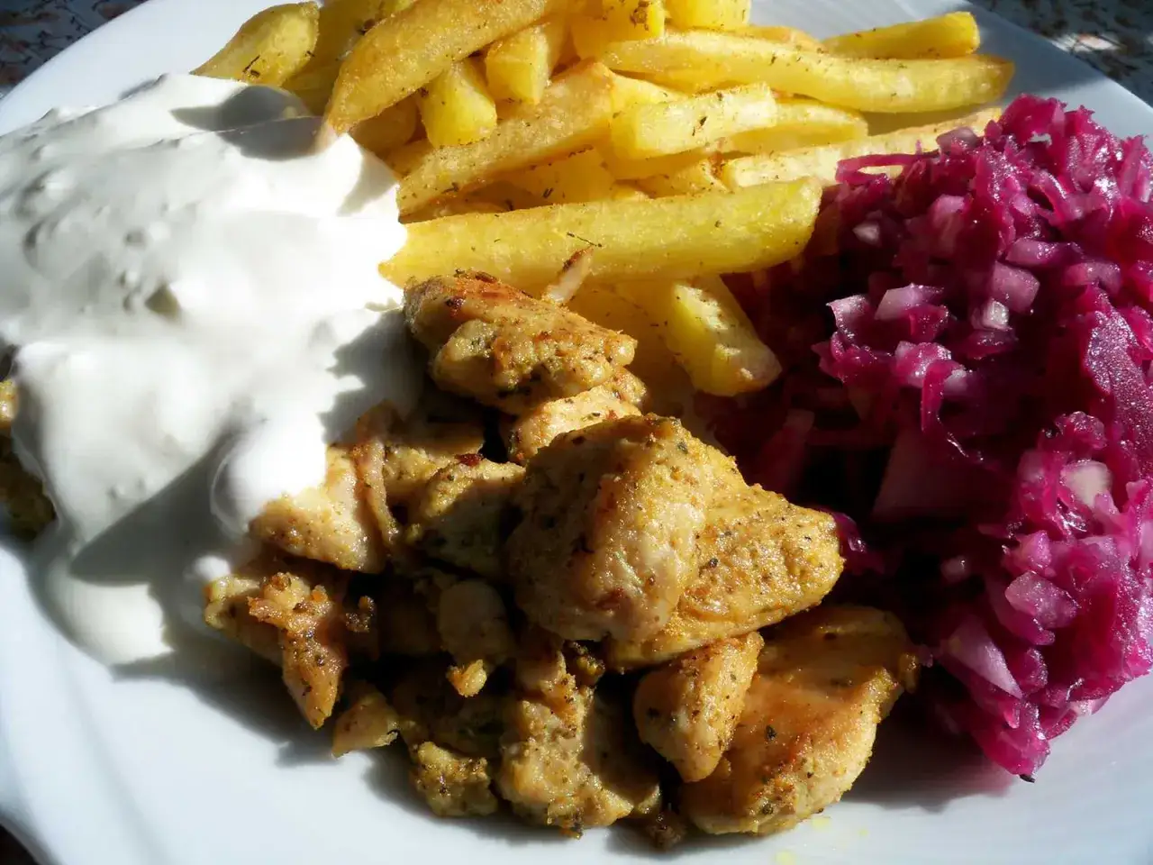 Idealne co do frytek na obiad: soczysty kurczak, chrupiące frytki, biały sos i surówka z czerwonej kapusty.