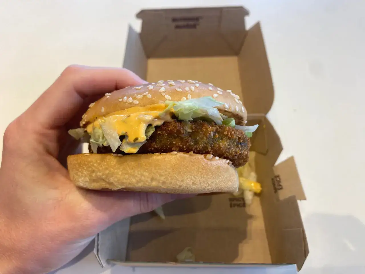 Ręka trzyma wege burgera z McDonald's. Zastanawiasz się nad jego kcal?